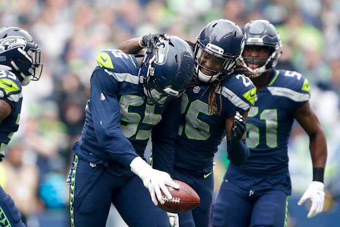 Seattle Seahawks defensive end Frank Clark (55) celebrates with cornerback Shaquill Griffin (26) after catching an interception against the Los Angeles Rams during the first quarter at CenturyLink Field.